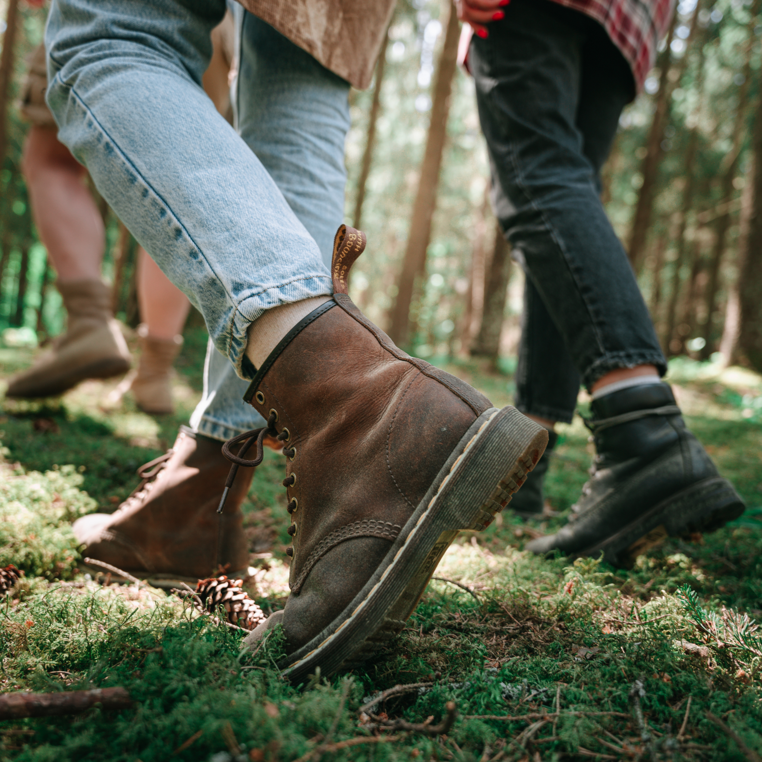 Menschen mit Wanderschuhen gehen durch einen Moosbedeckten Wald