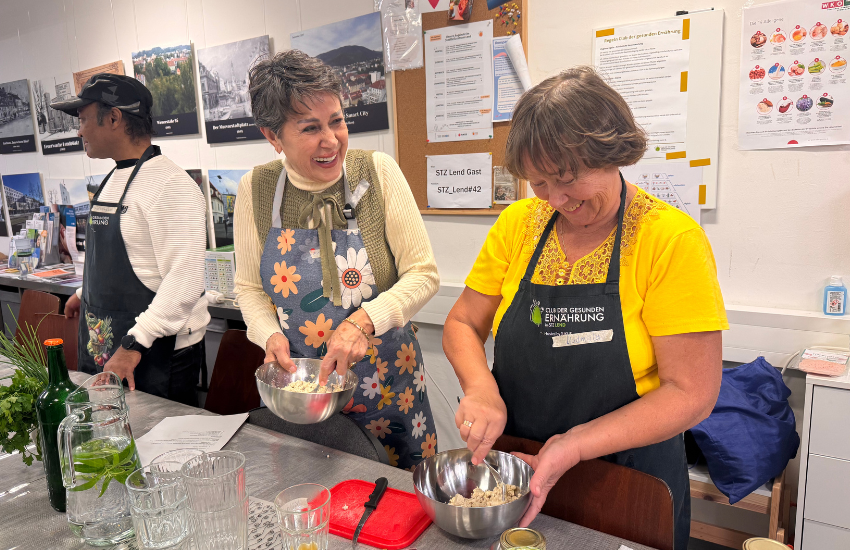 2 Frauen kochen gemeinsam und rühren in Schüsseln